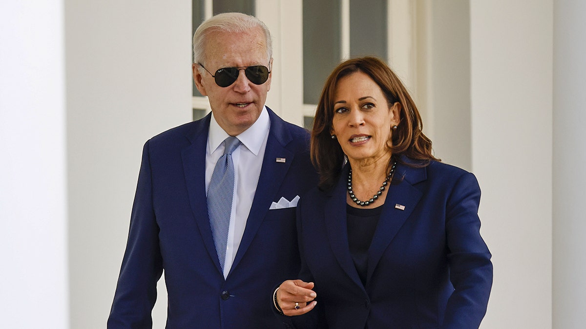 President Biden and Vice President Harris appear to be chatting as they walk through the Colonnade of the White House in Washington, D.C.