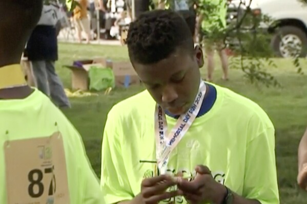 Ralph Yarl looks at a badge that he received after walking at a brain injury awareness event, May 29, 2023, in Kansas City, Mo. (KCTV via AP, File)