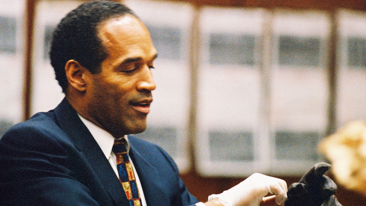 O.J. Simpson tries on a leather glove allegedly used in the murders of Nicole Brown Simpson and Ronald Goldman