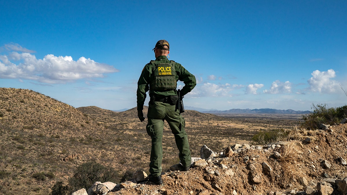 border patrol agent stands on cliff in Arizona