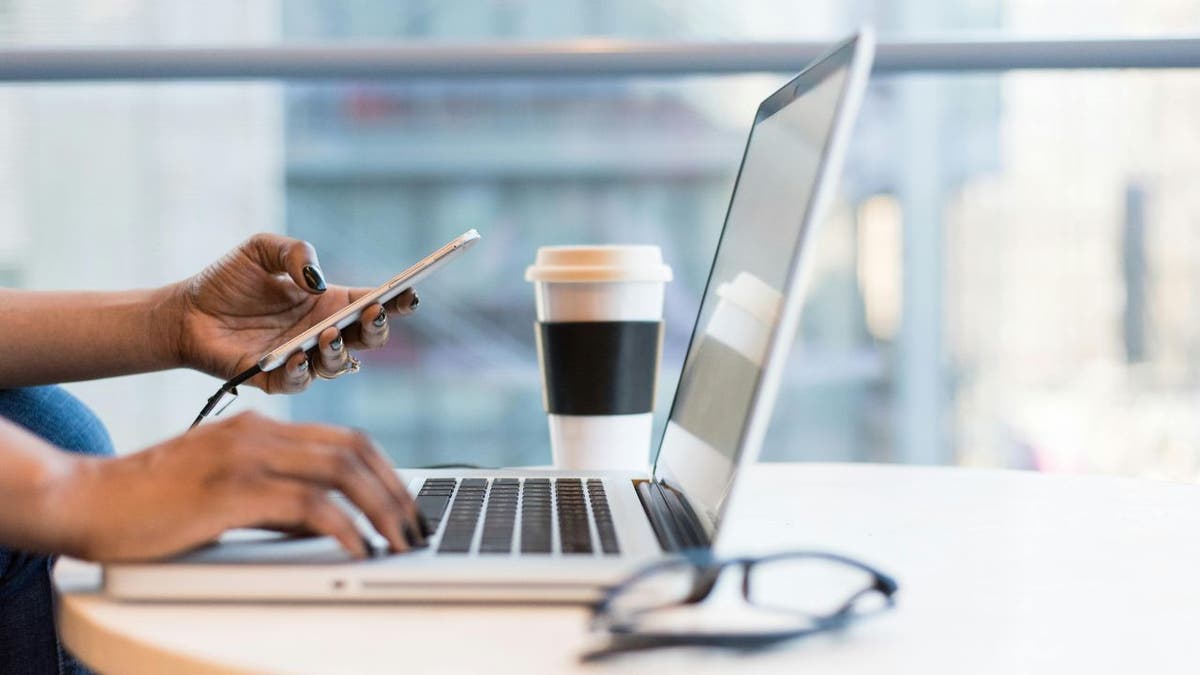 woman with phone and laptop