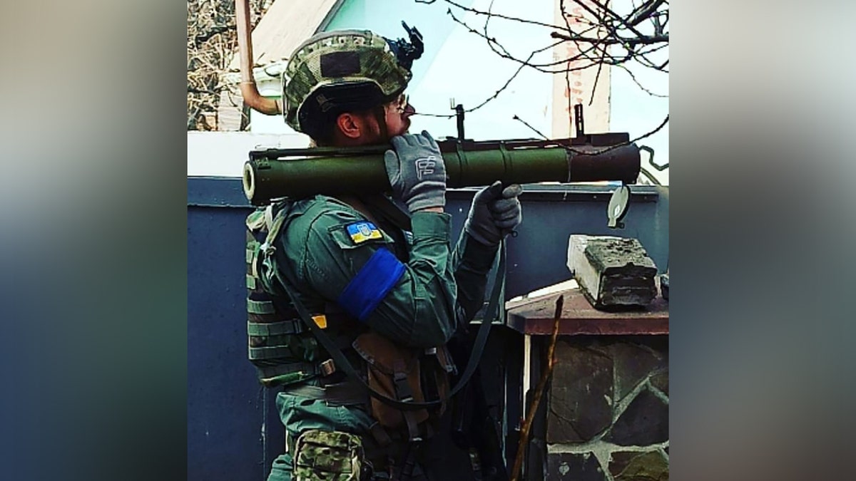 A man with a helmet holding a large weapon.