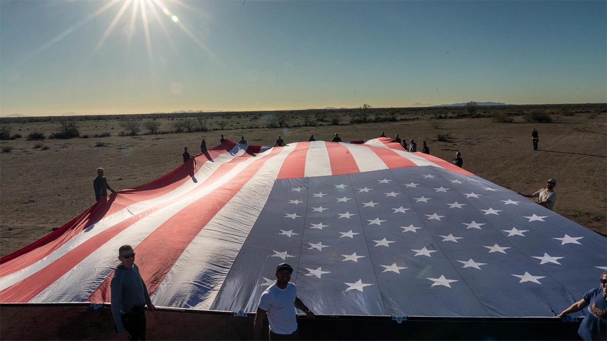Team members held a fully opened 3,200-square-foot American flag on the ground during the record attempt.