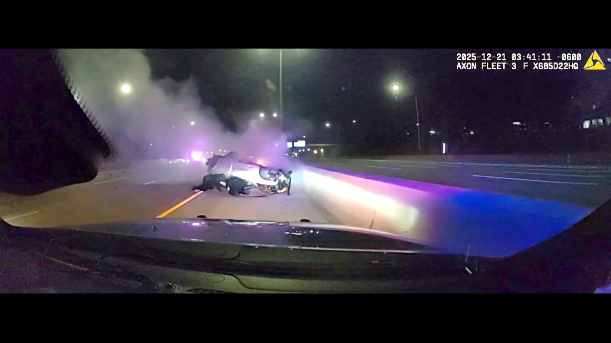 Officers crawling under car wreck