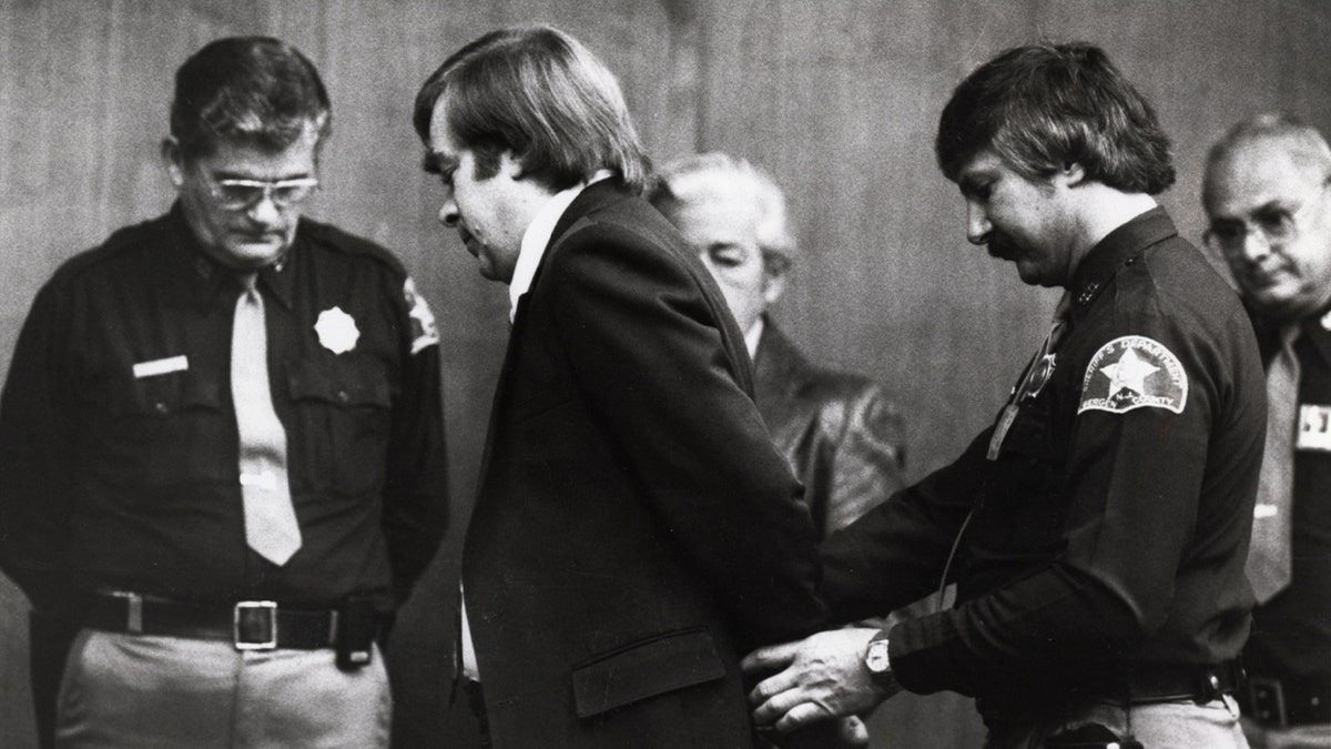 Court officers handcuff convicted Richard Cottingham in a black and white photo from 1982