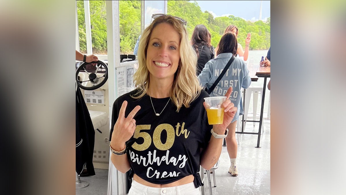 Courtney Shaw holding peace sign while holding beverage