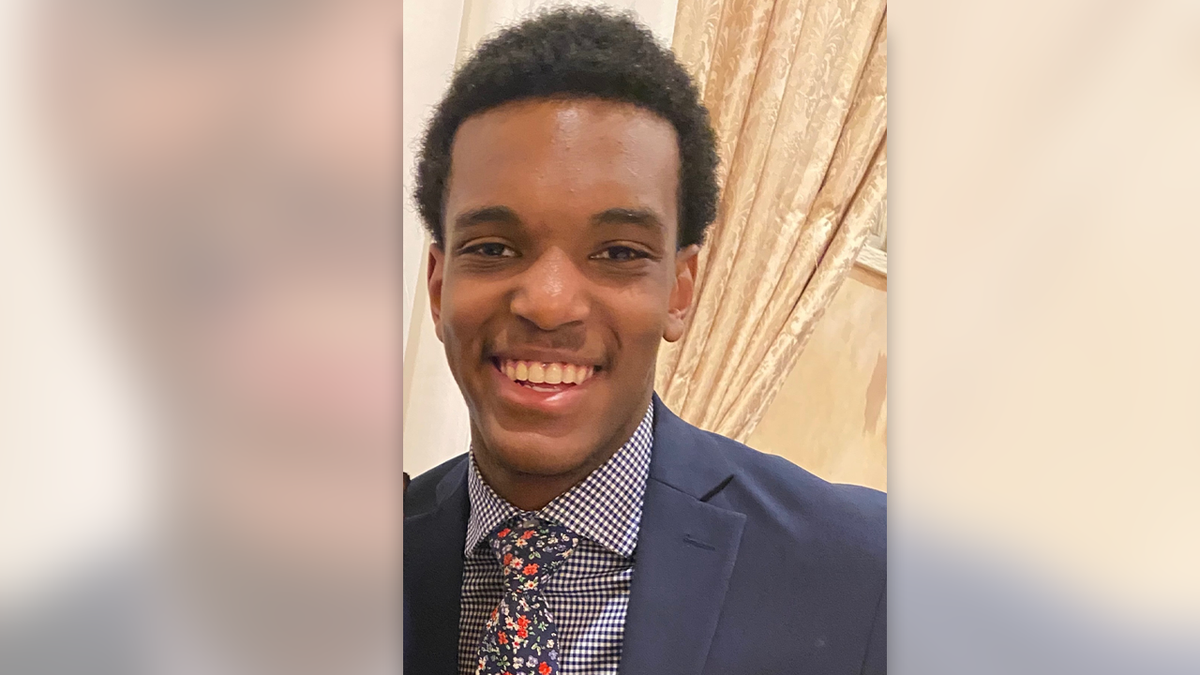 Eddy Cine Jr appears in a dark suit and colorful tie