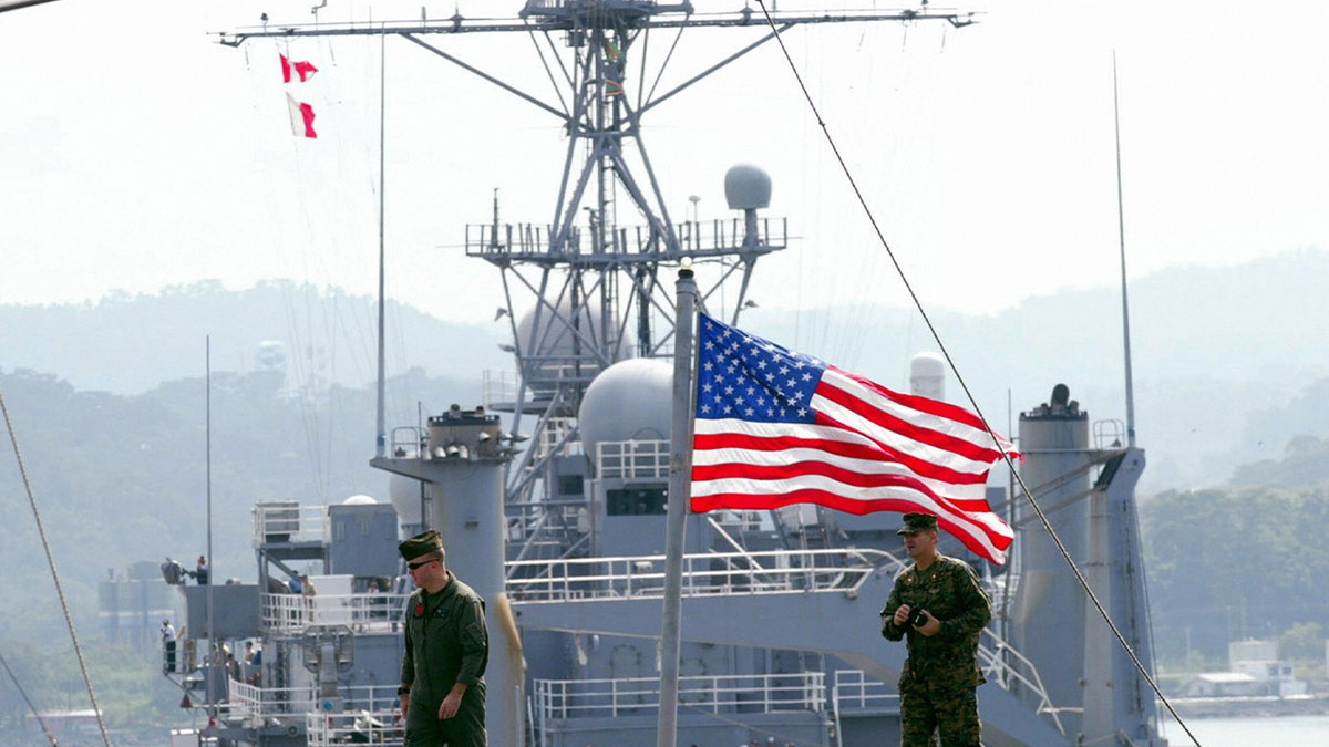 US soldiers walk on the deck of USS Essex while USS Juneau (background) and USS Harper (not in the photo) arrives at the Subic port, a former US naval base northwest of Manila 17 October 2006.