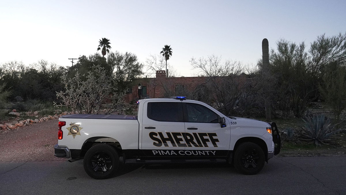 A member of the Pima County Sheriff's office standing outside Nancy Guthrie‘s house.