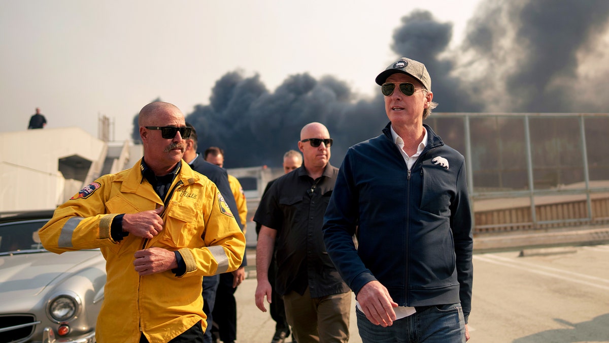 Gov. Newsom, right, in dark clothing, eyeglasses with first responders