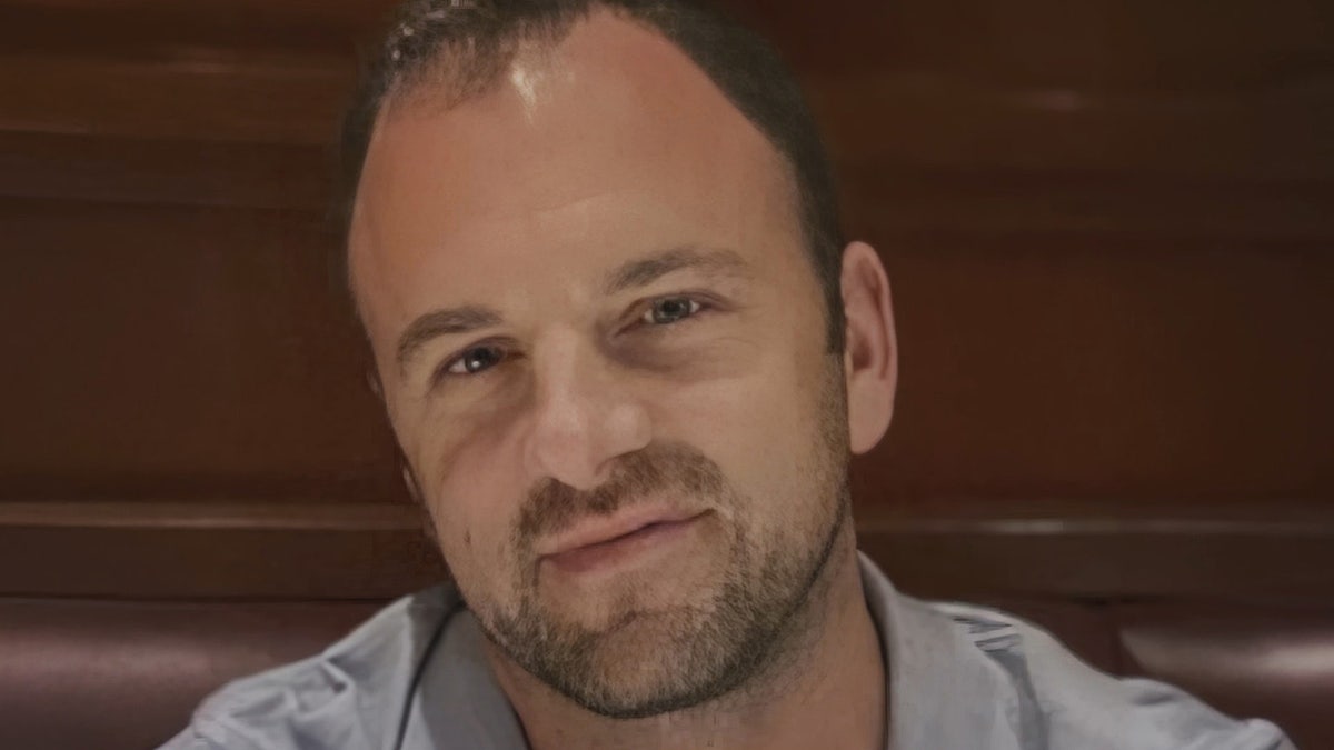 A close-up of John O'Keefe wearing a grey shirt.