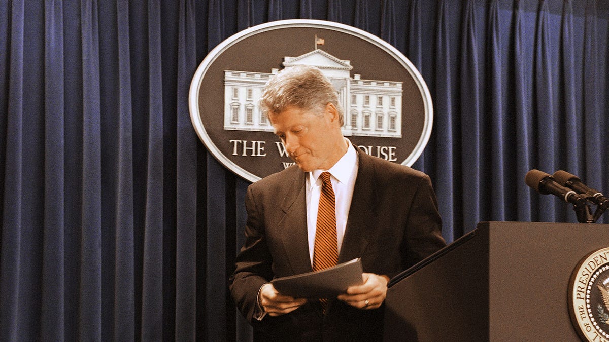 President Bill Clinton looking somber on stage