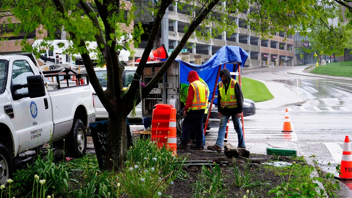 Workers fix the traffic lights at Martin Luther King Drive and Burnet Woods in Corryville, a day after a Hamilton County Sheriff's deputy was struck and killed while directing traffic for the University of Cincinnati commencement on May 2, 2025.