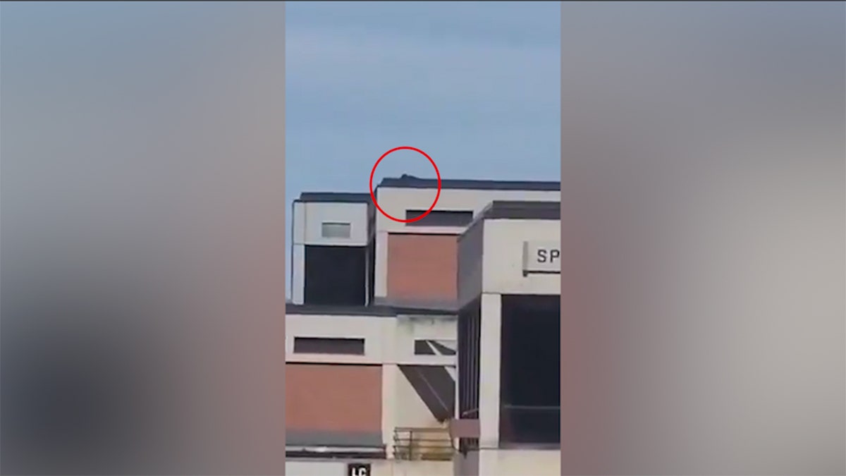 a red circle around what appears to be a person in black laying down on a rooftop at Utah Valley University