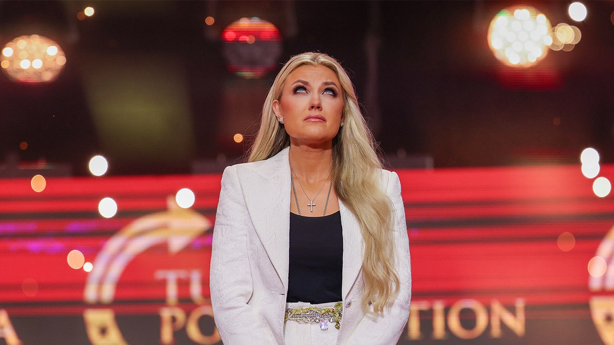 Erika Kirk looking upwards on stage at Charlie Kirk memorial.