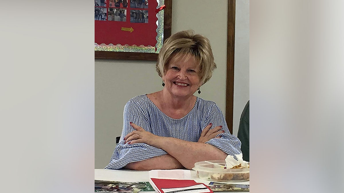 Anita Avers smiling in a 2021 photo, wearing a striped blouse.