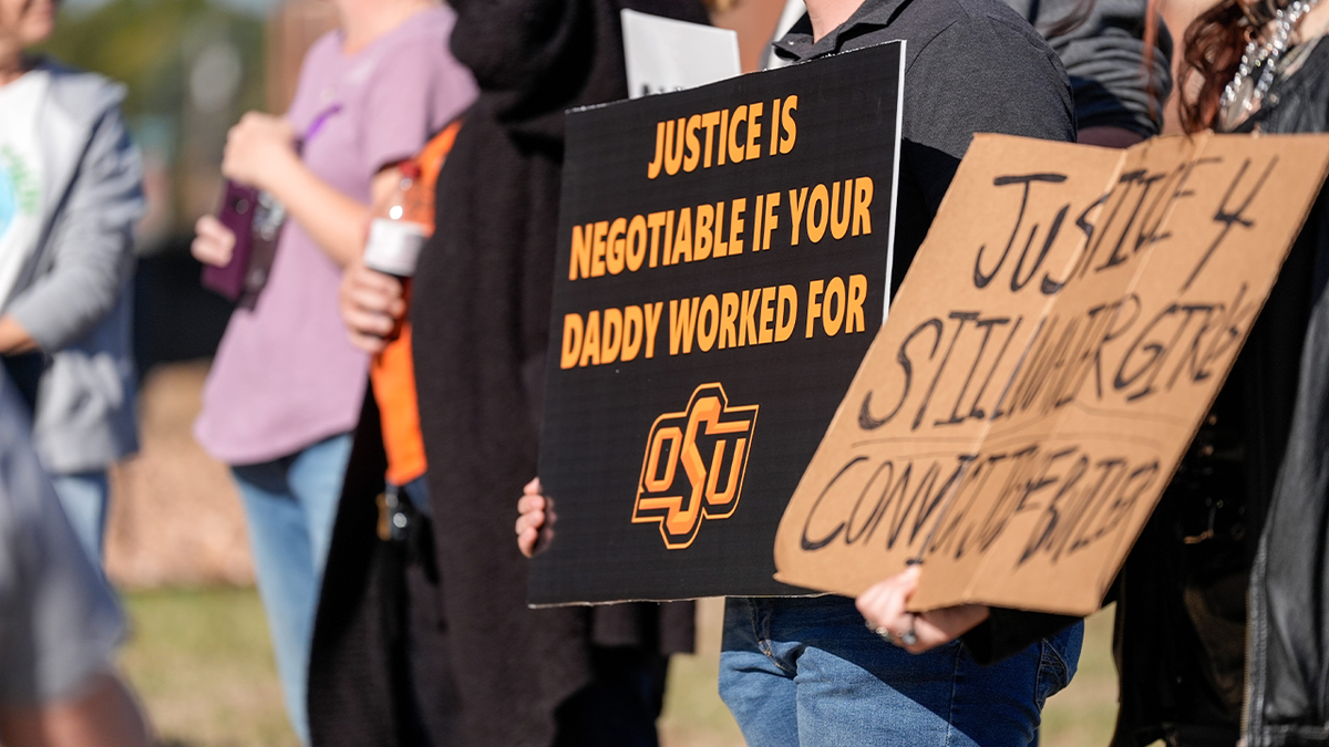 People hold signs protesting Jesse Butler sentence