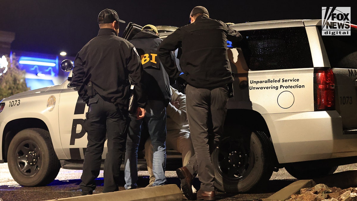A man being detained by law enforcement during a traffic stop in Tucson, Arizona.